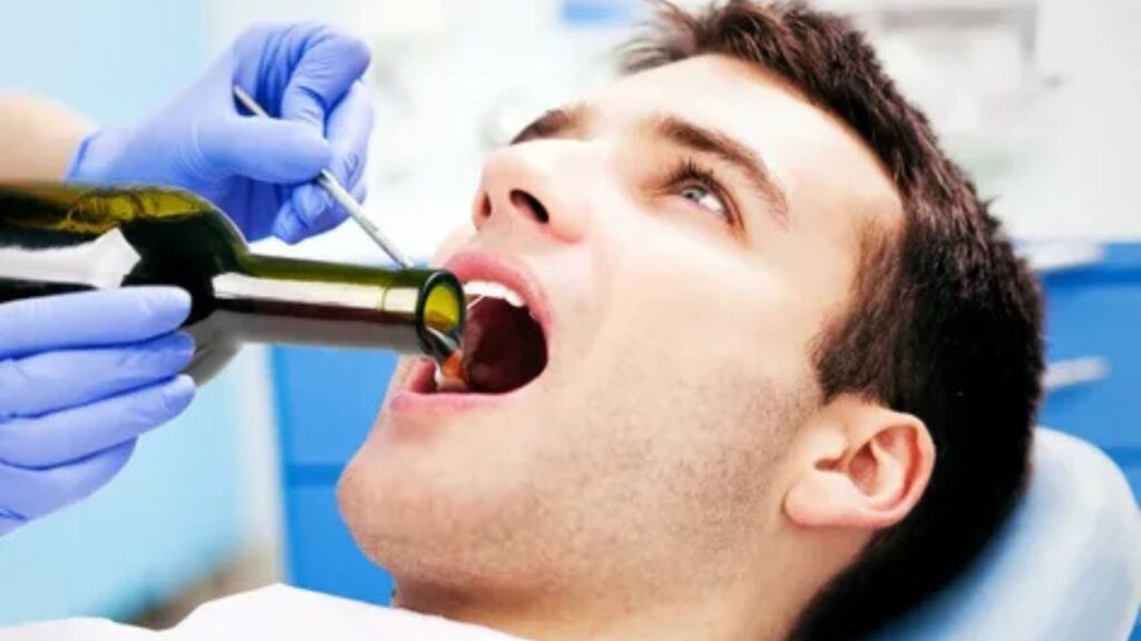 "Patient in dental chair with wine bottle in mouth, illustrating risks of drinking alcohol too soon after crown placement."