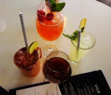 A table with colorful cocktails and drinks served with straws at a Las Vegas lounge, representing the best times and occasions to enjoy unlimited drink offers.