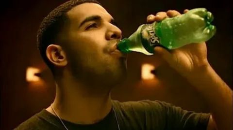 A person drinking from a green Sprite bottle, illustrating the consumption of a high-sugar soft drink that provides a quick but unsustainable energy boost followed by a crash.